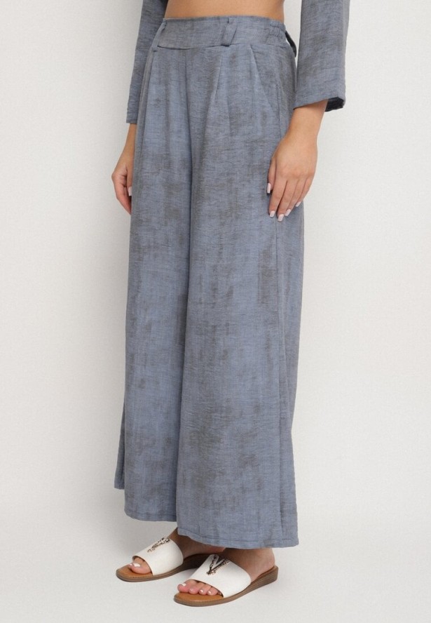 Niebieski Komplet Bluzka z Rozkloszowanym Dołem i Aplikacją Kwiatka i Luźne Spodnie Ravirisa